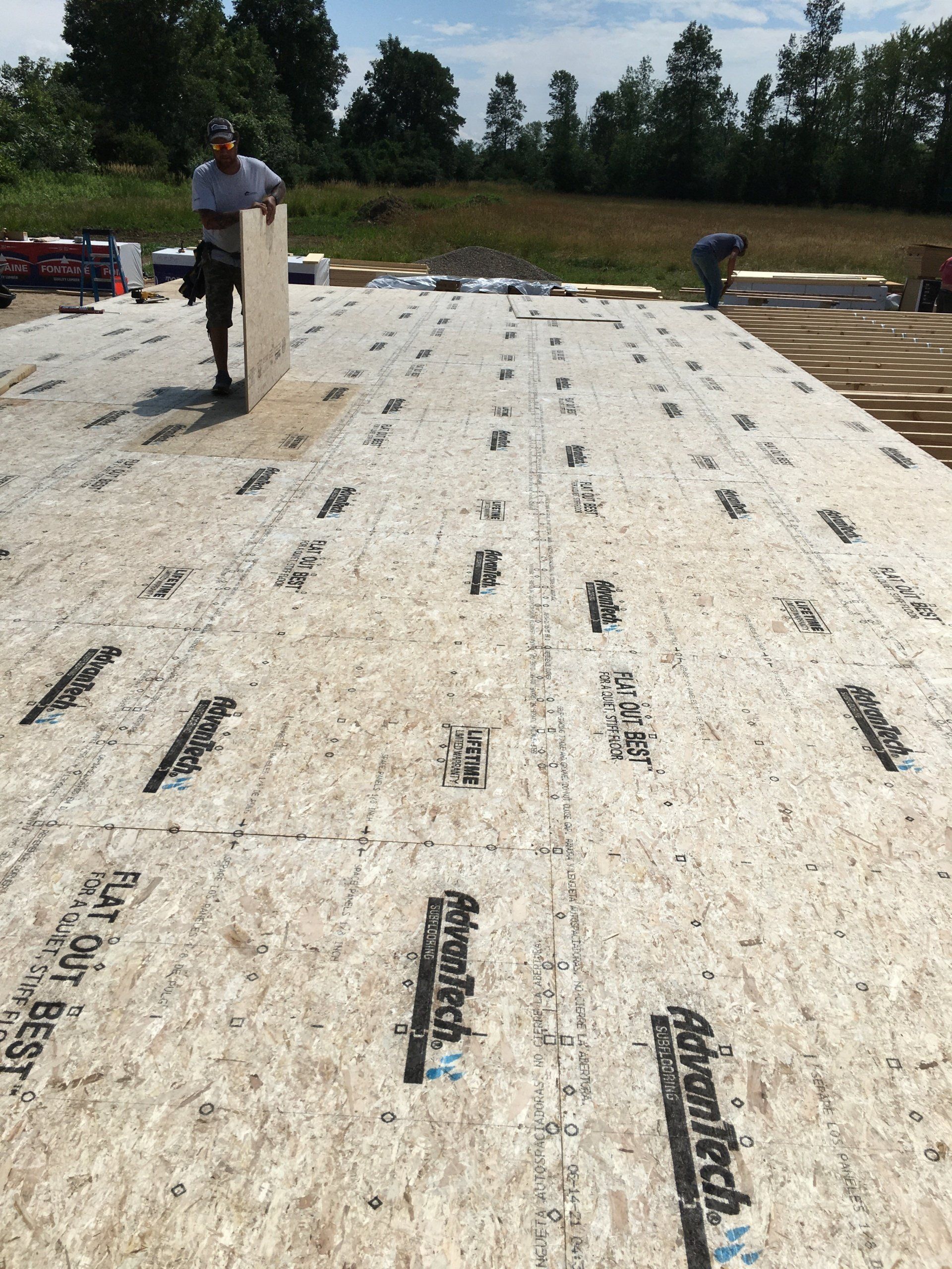 A man is standing on top of a roof that has advanced written on it