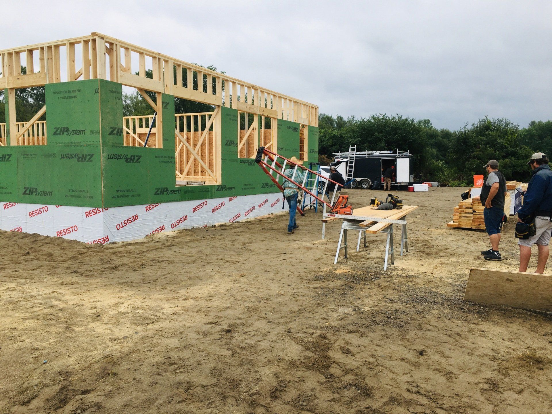 A house is being built in a dirt field.