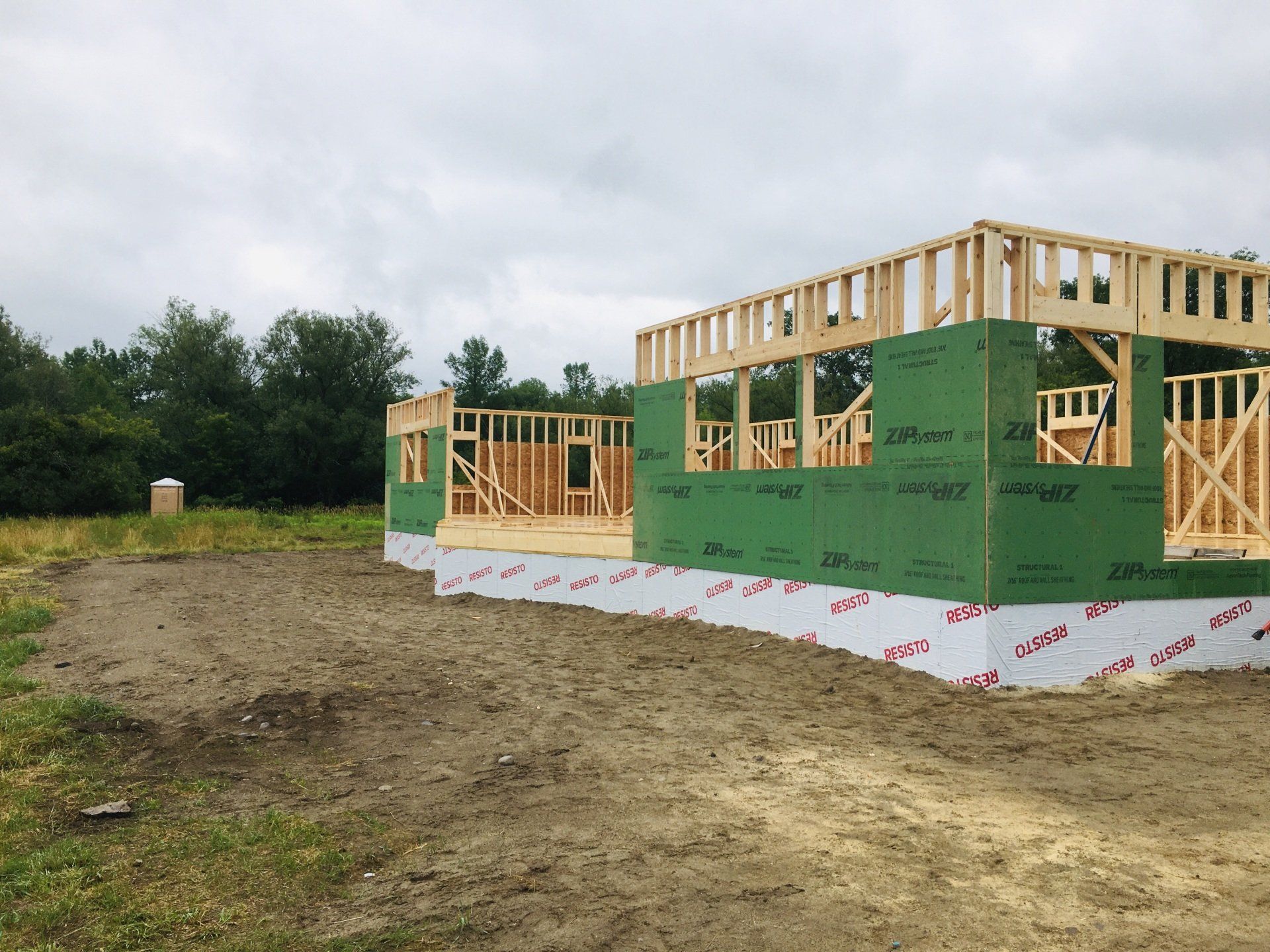 A house is being built in a dirt field.