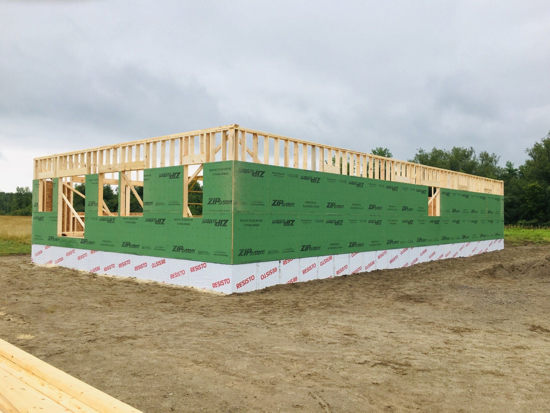 A house is being built in the middle of a dirt field.