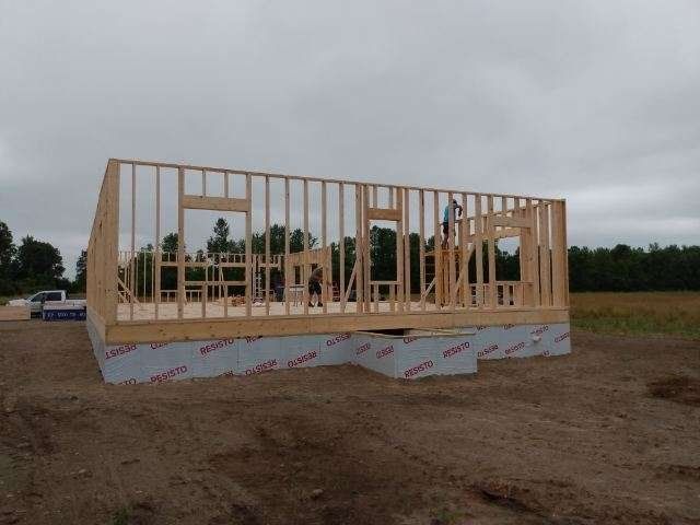 A house is being built in the middle of a dirt field