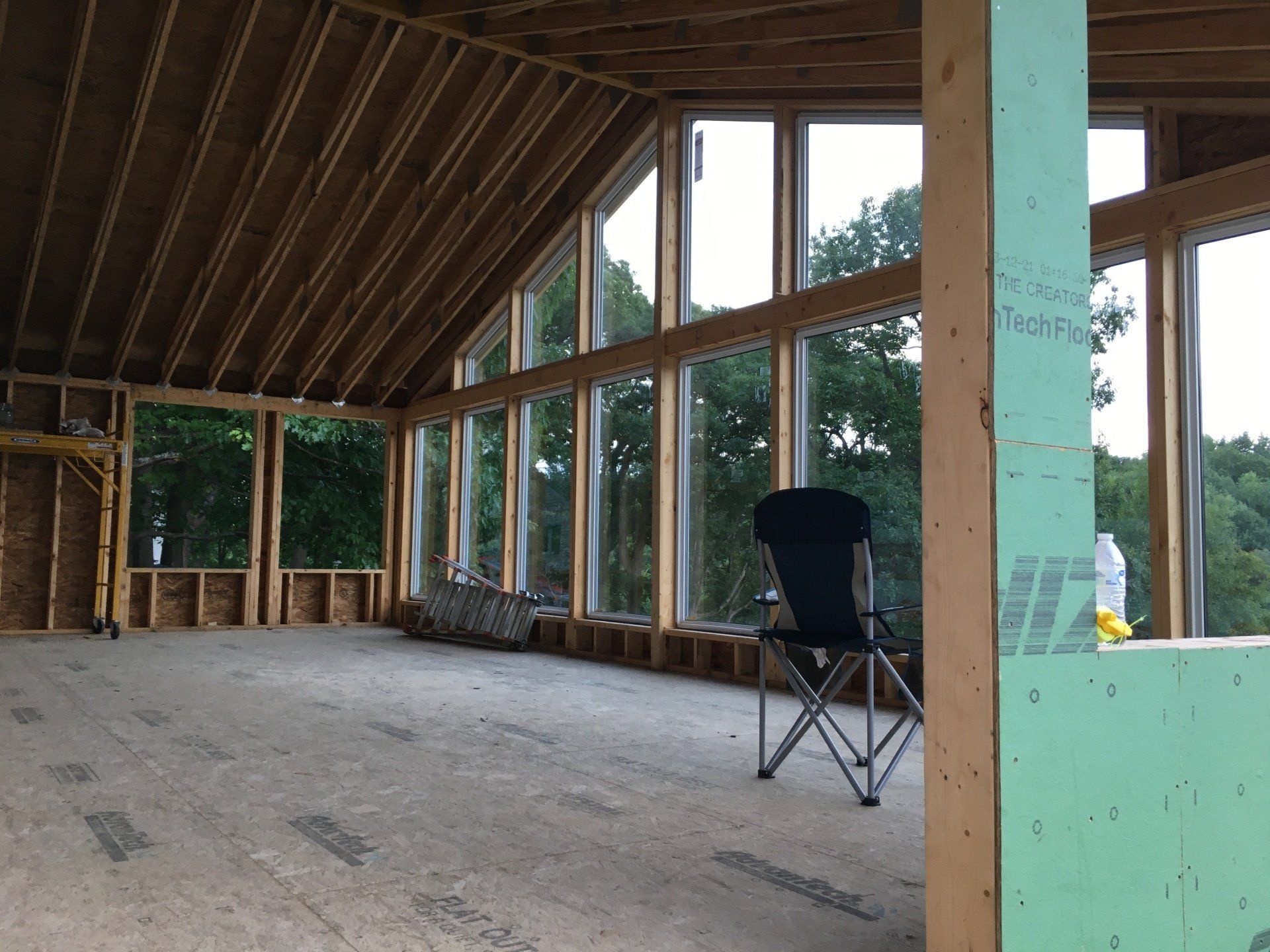 A chair sits in a room with a lot of windows