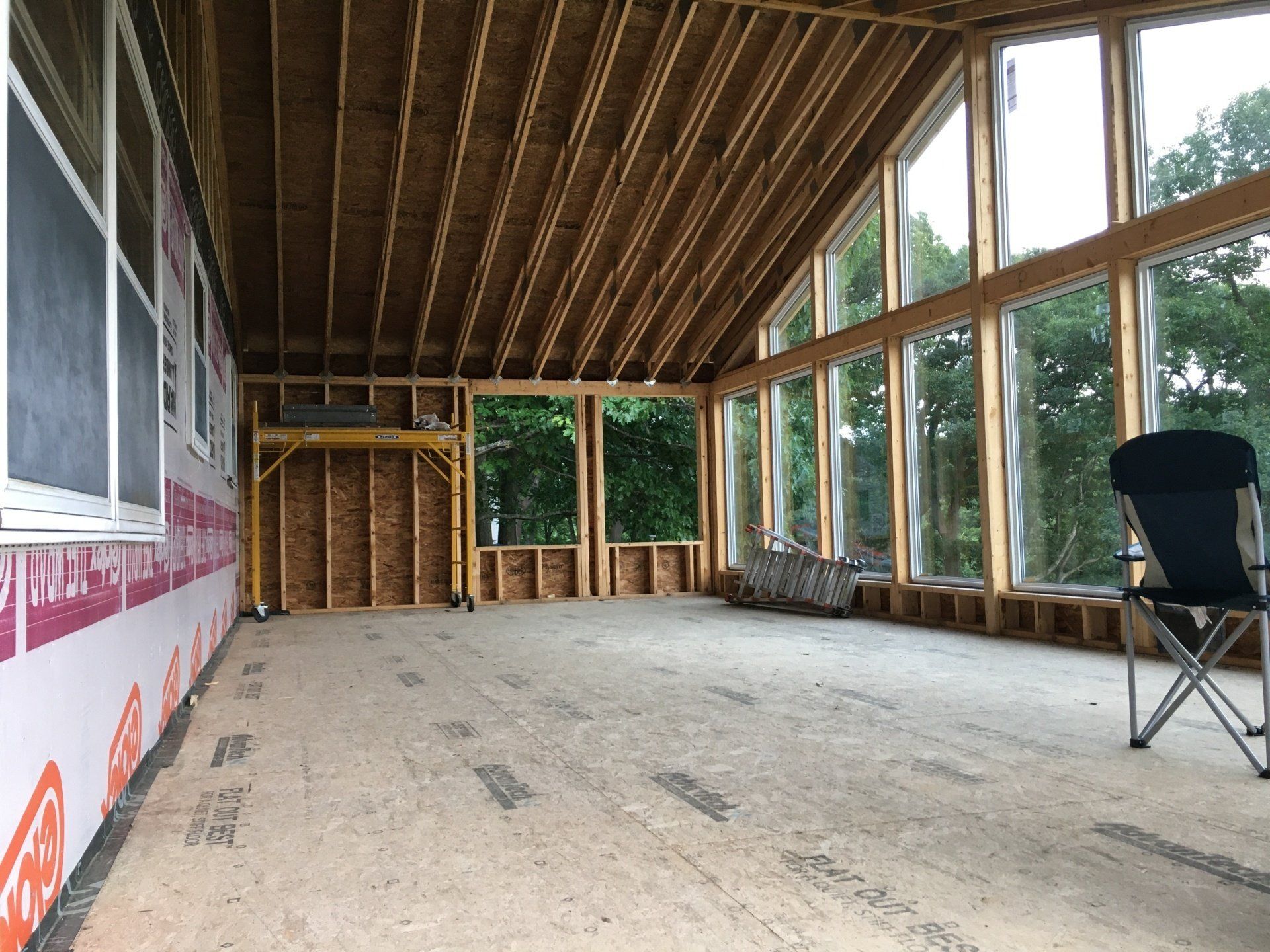 A large room with a lot of windows and a chair in it.