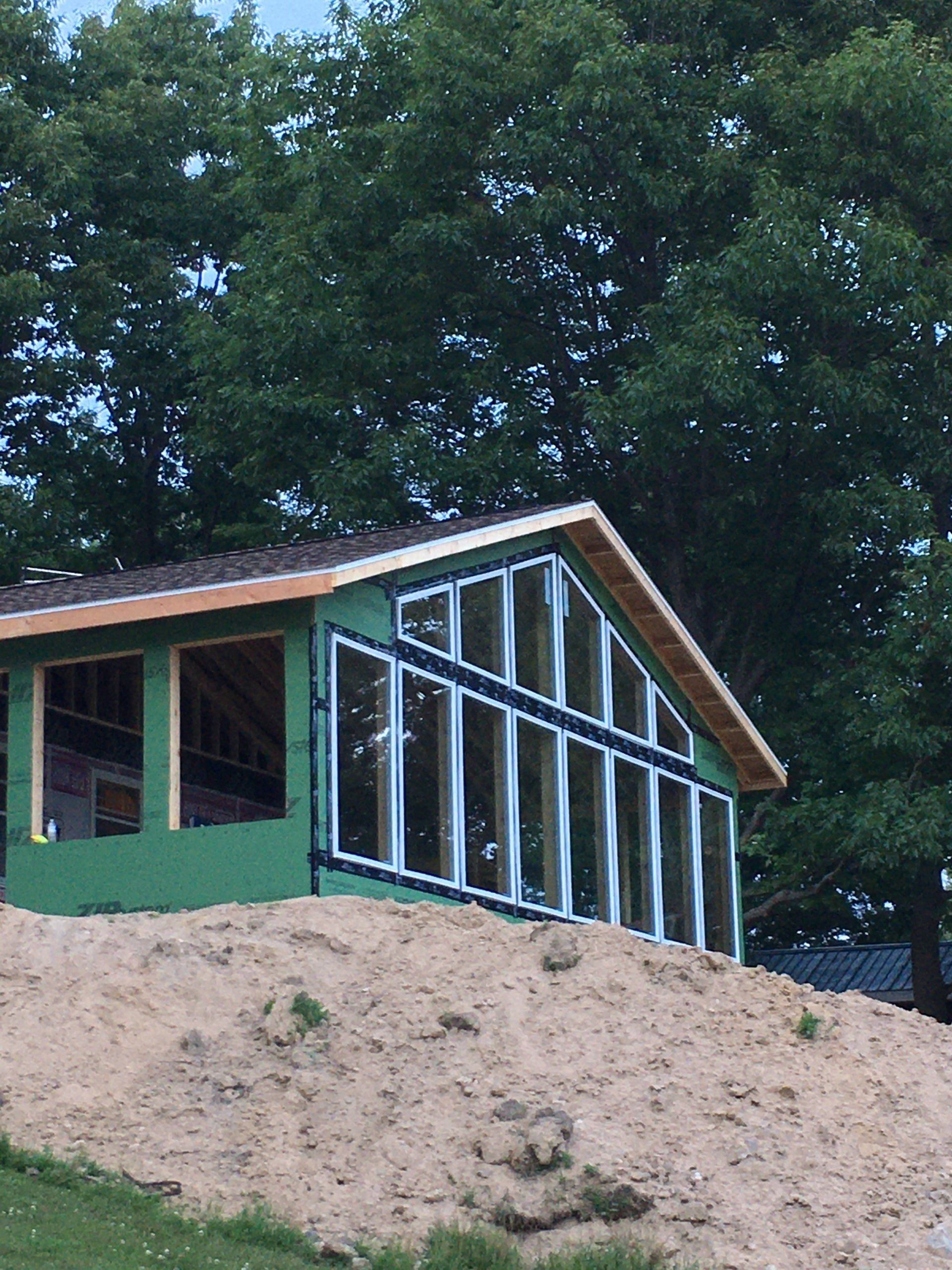 A green house is being built on top of a hill