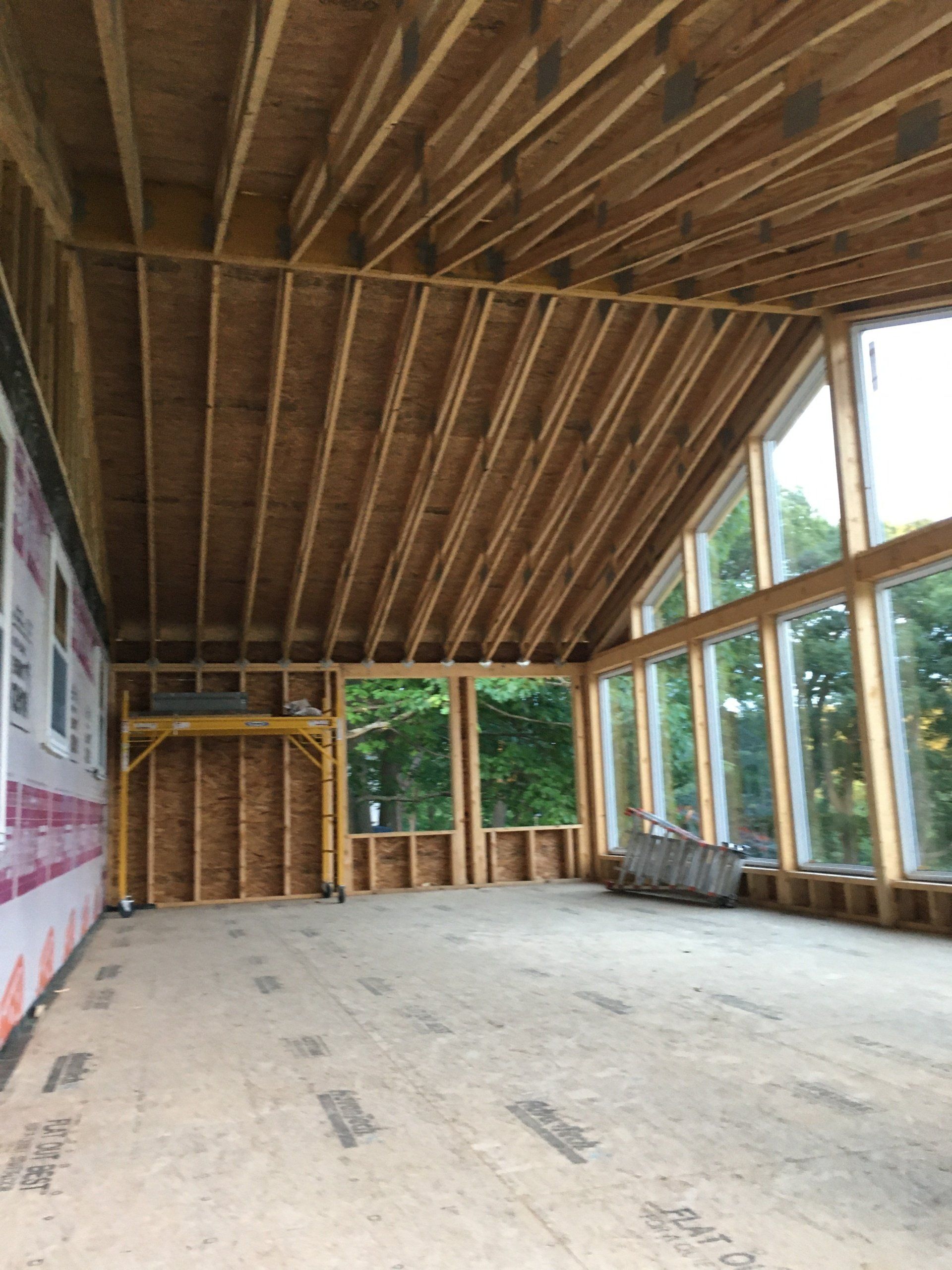 A large room with a lot of windows and wooden beams.