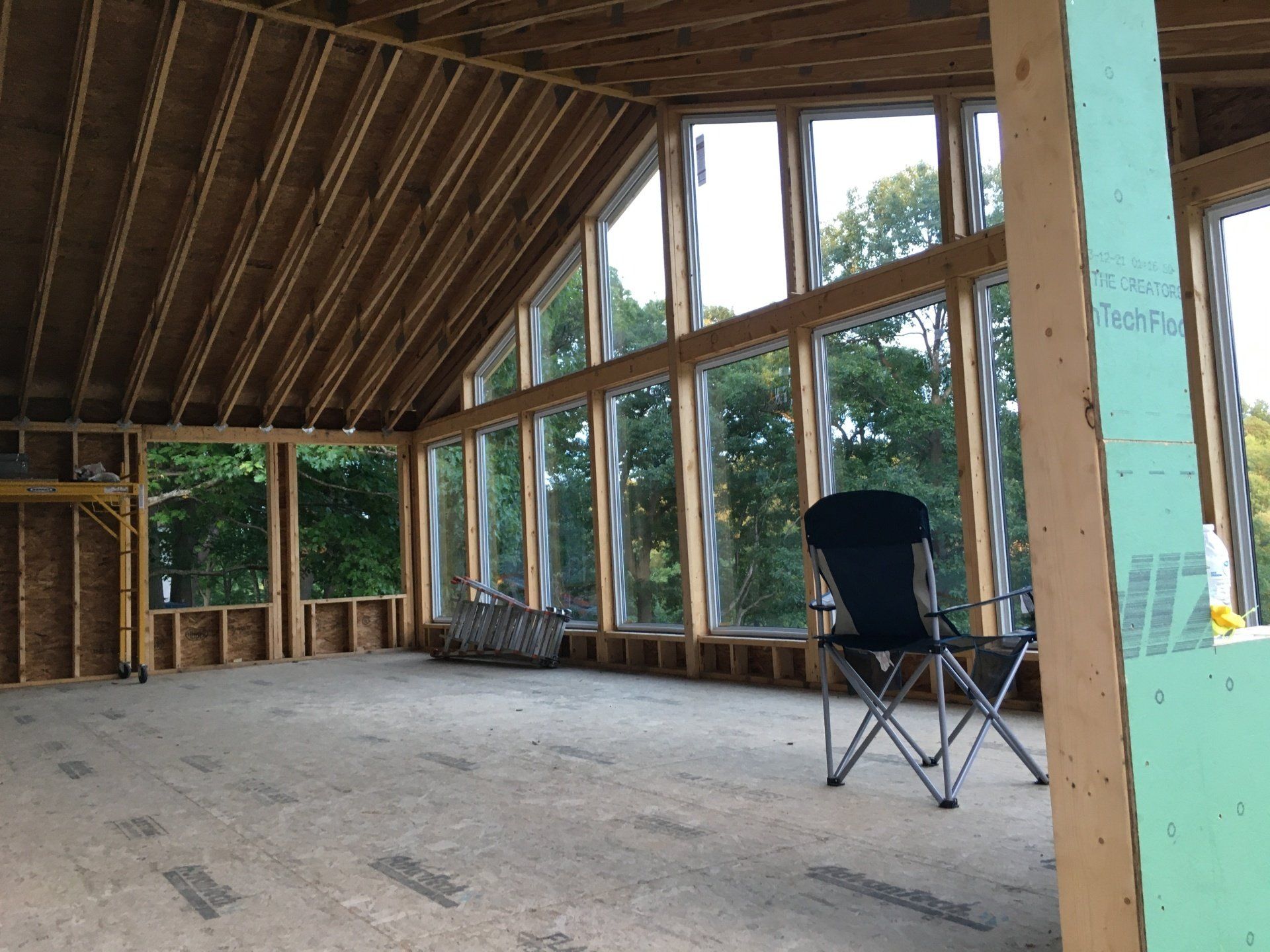 A room with a lot of windows and a chair in it