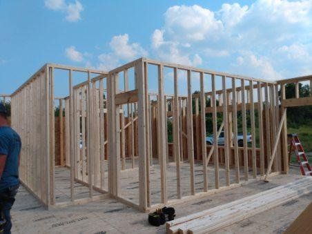 A man is standing in front of a building under construction.