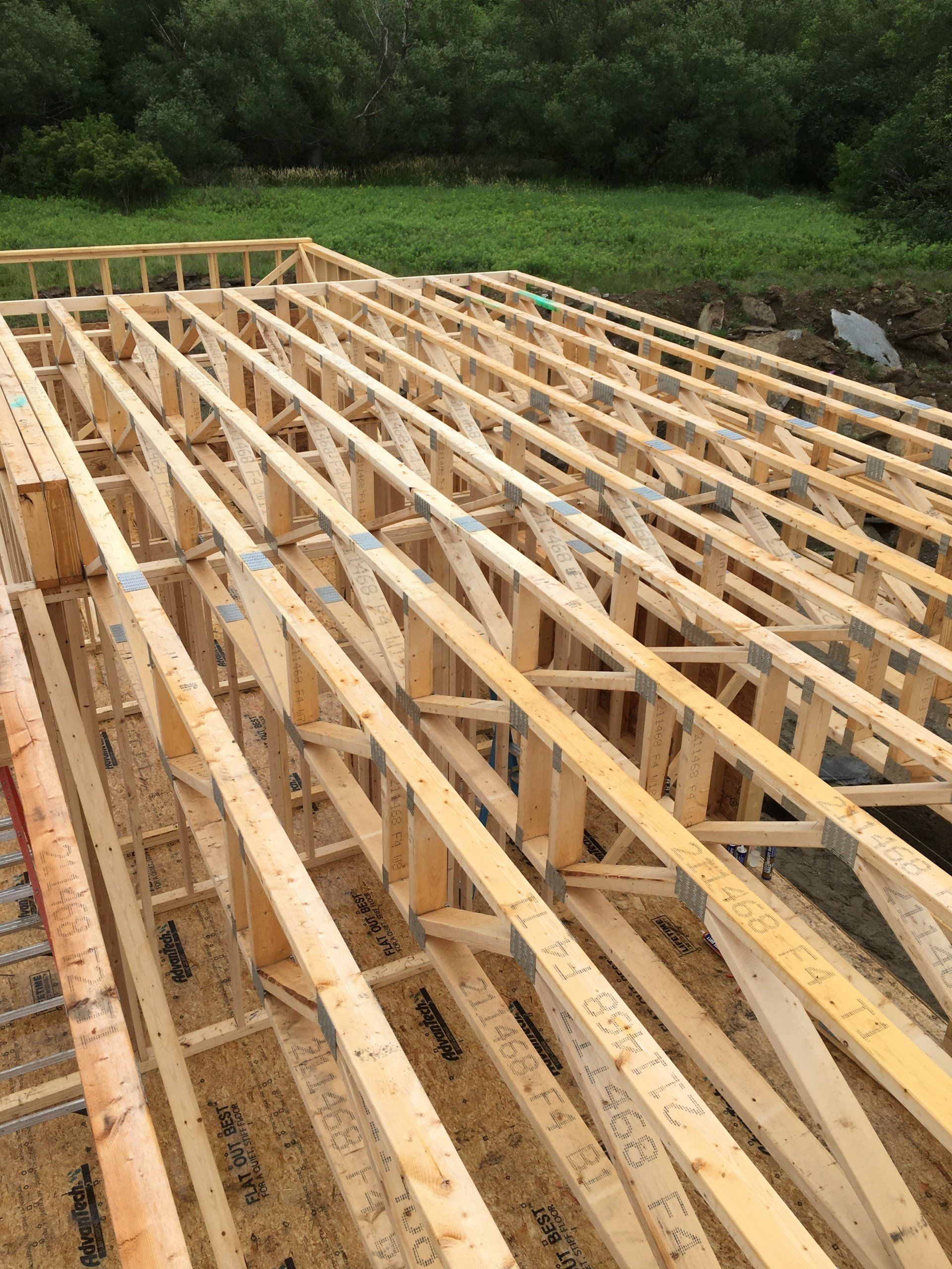 A large wooden structure is being built in a field.