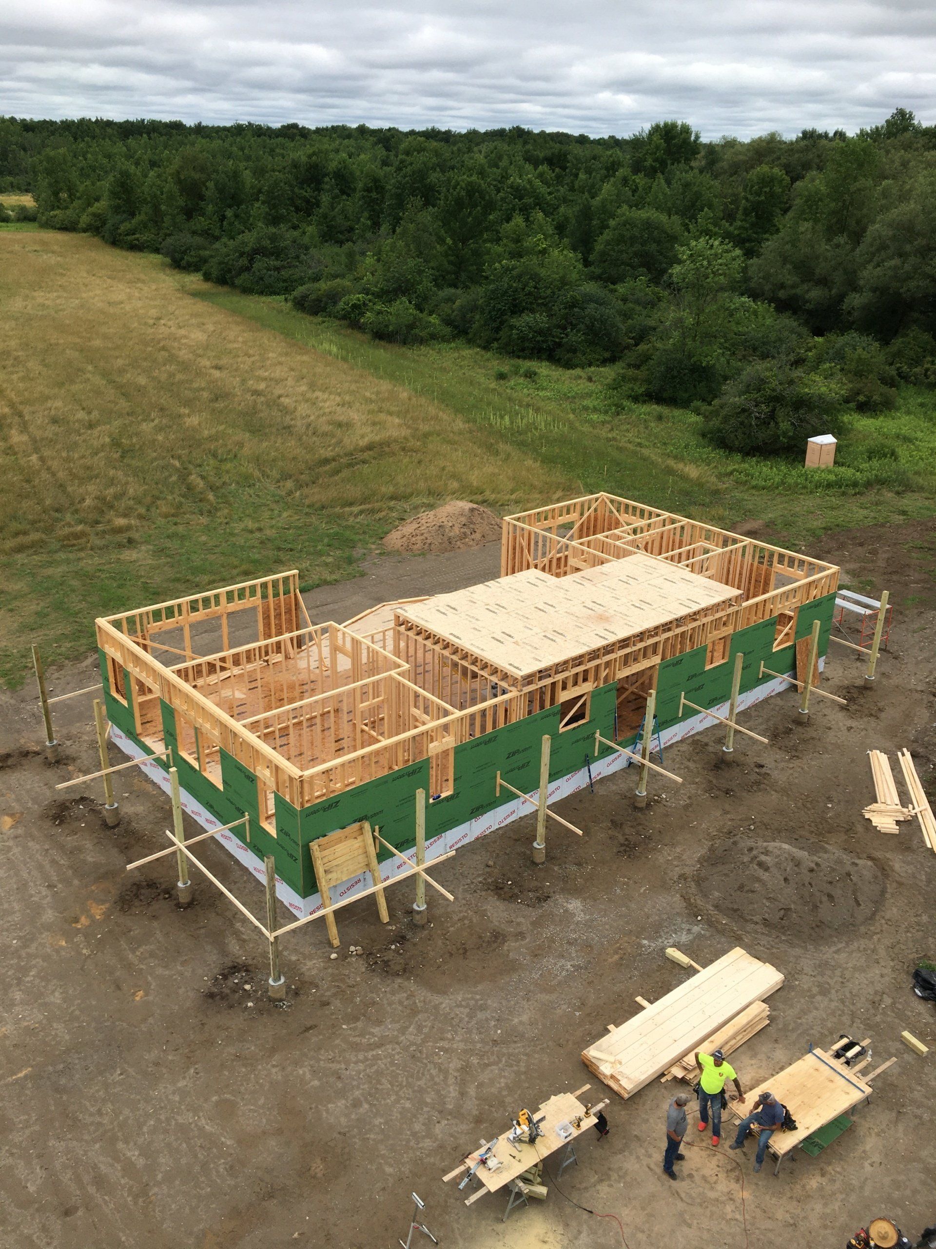 An aerial view of a house under construction in a field.