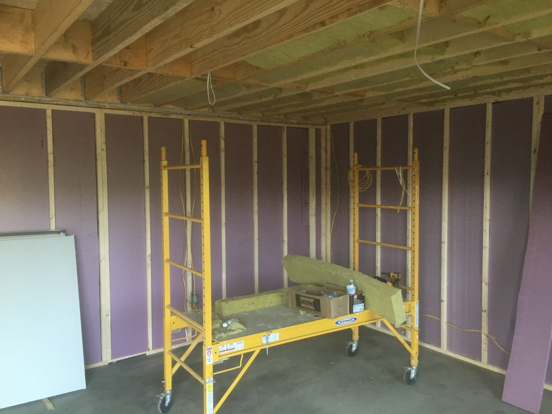 A yellow scaffolding is sitting in a room with purple walls.