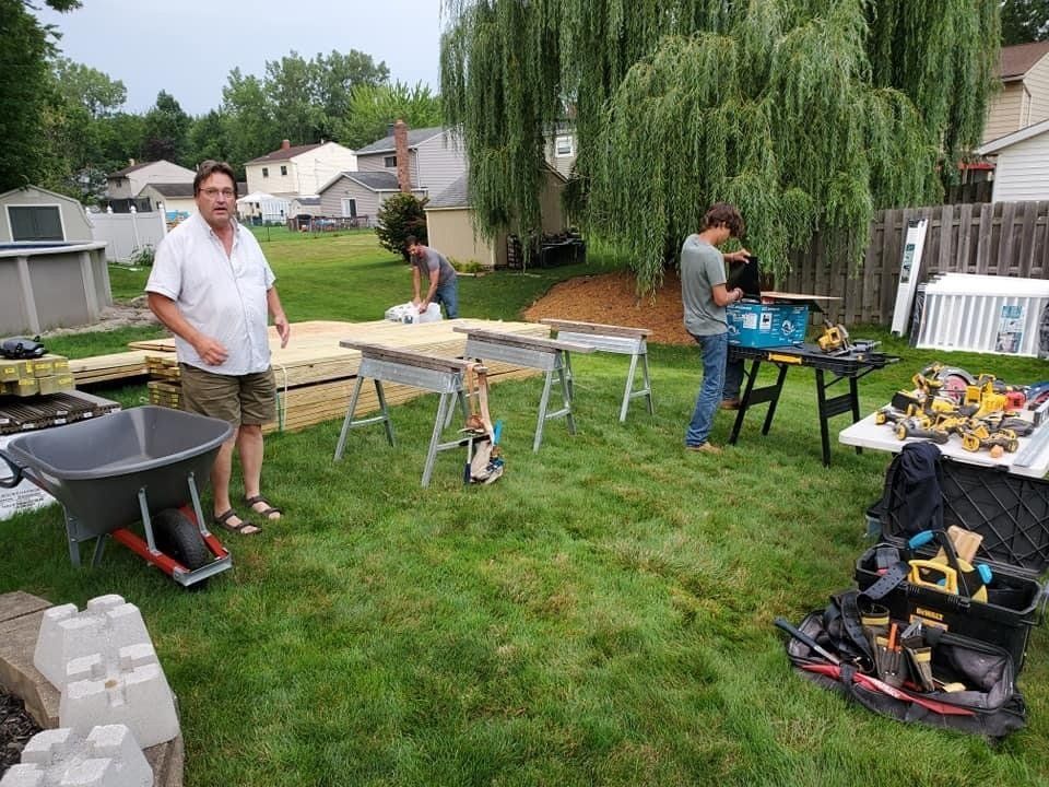 A group of men are working on a project in a backyard.