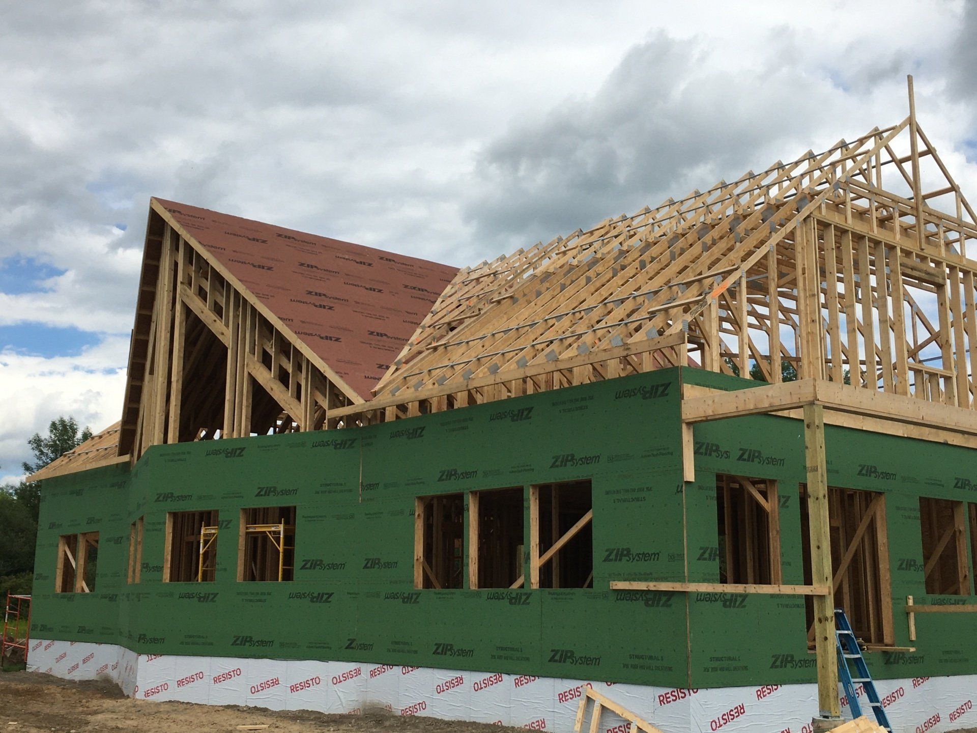 A large house is being built with a red roof.