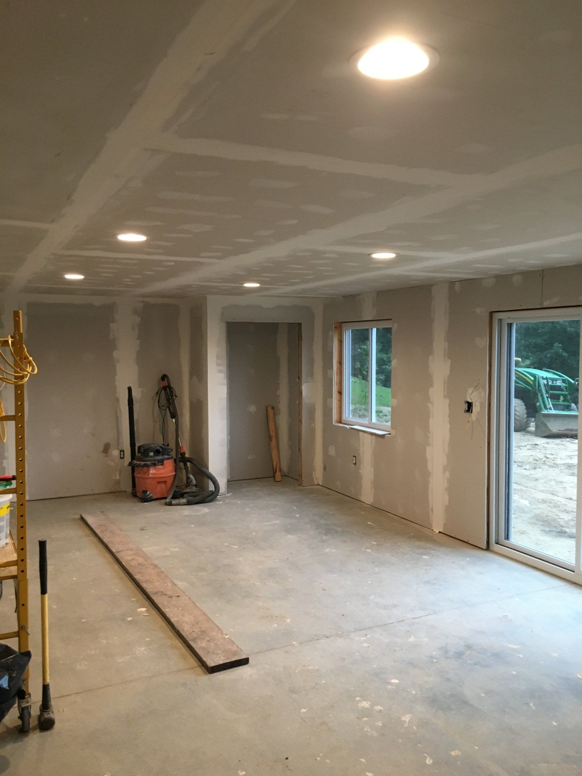 A large room with a lot of windows and a vacuum cleaner in it.