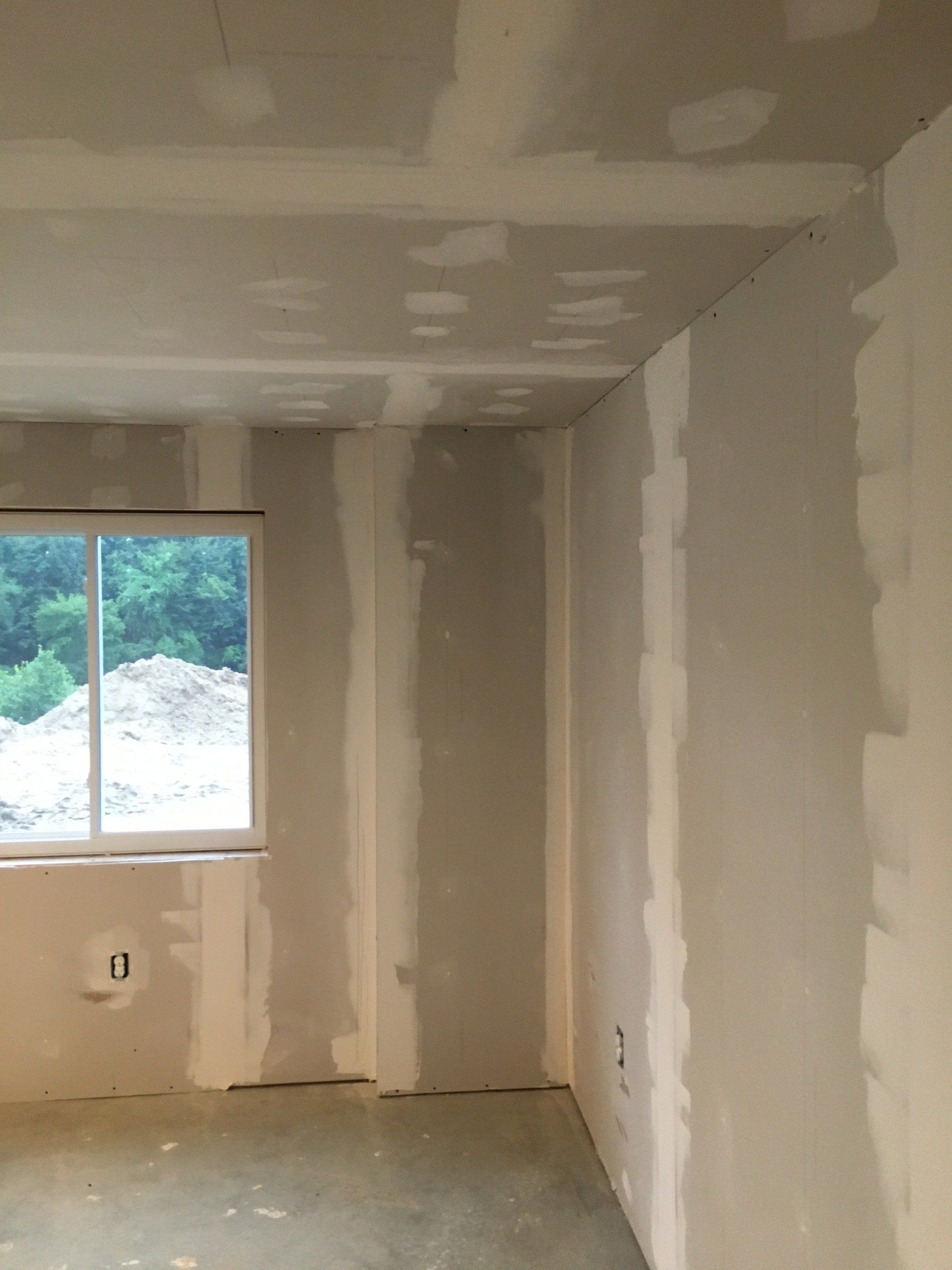 An empty room with drywall walls and a window.