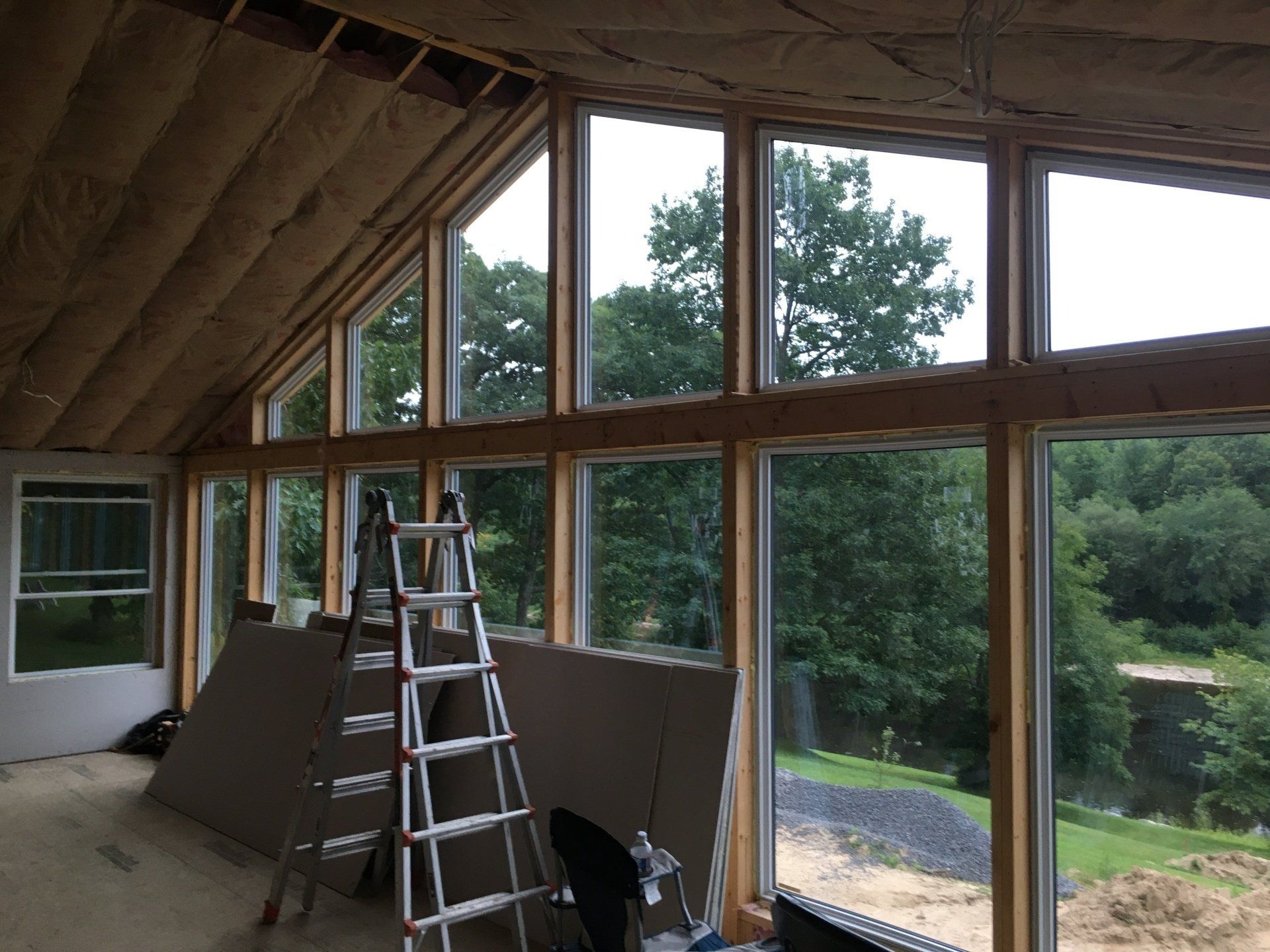 A room with a lot of windows and a ladder