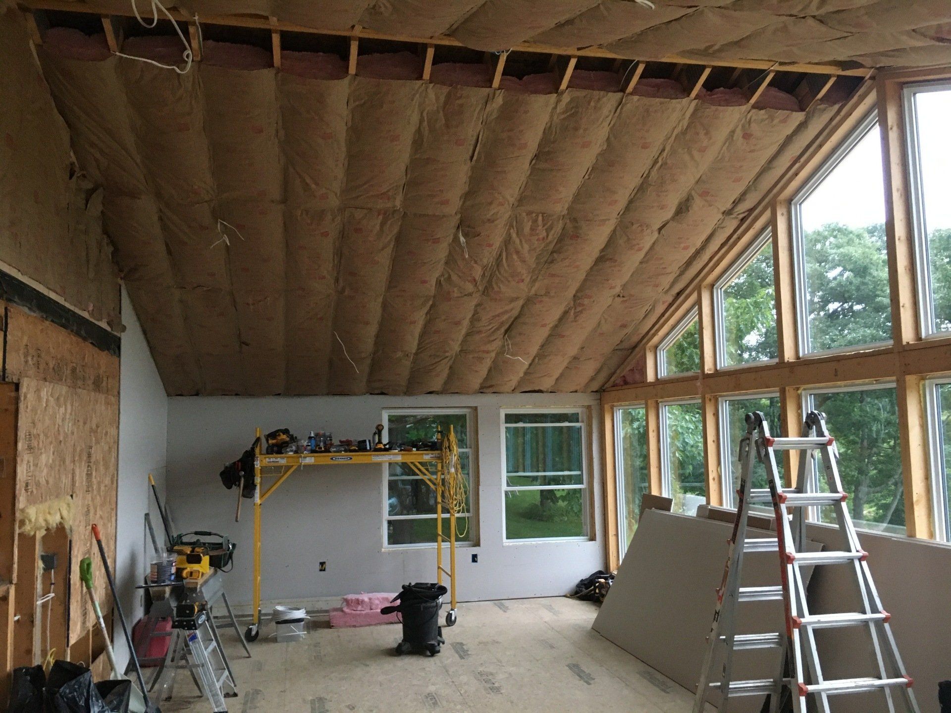 A room with a lot of windows and a ladder in it