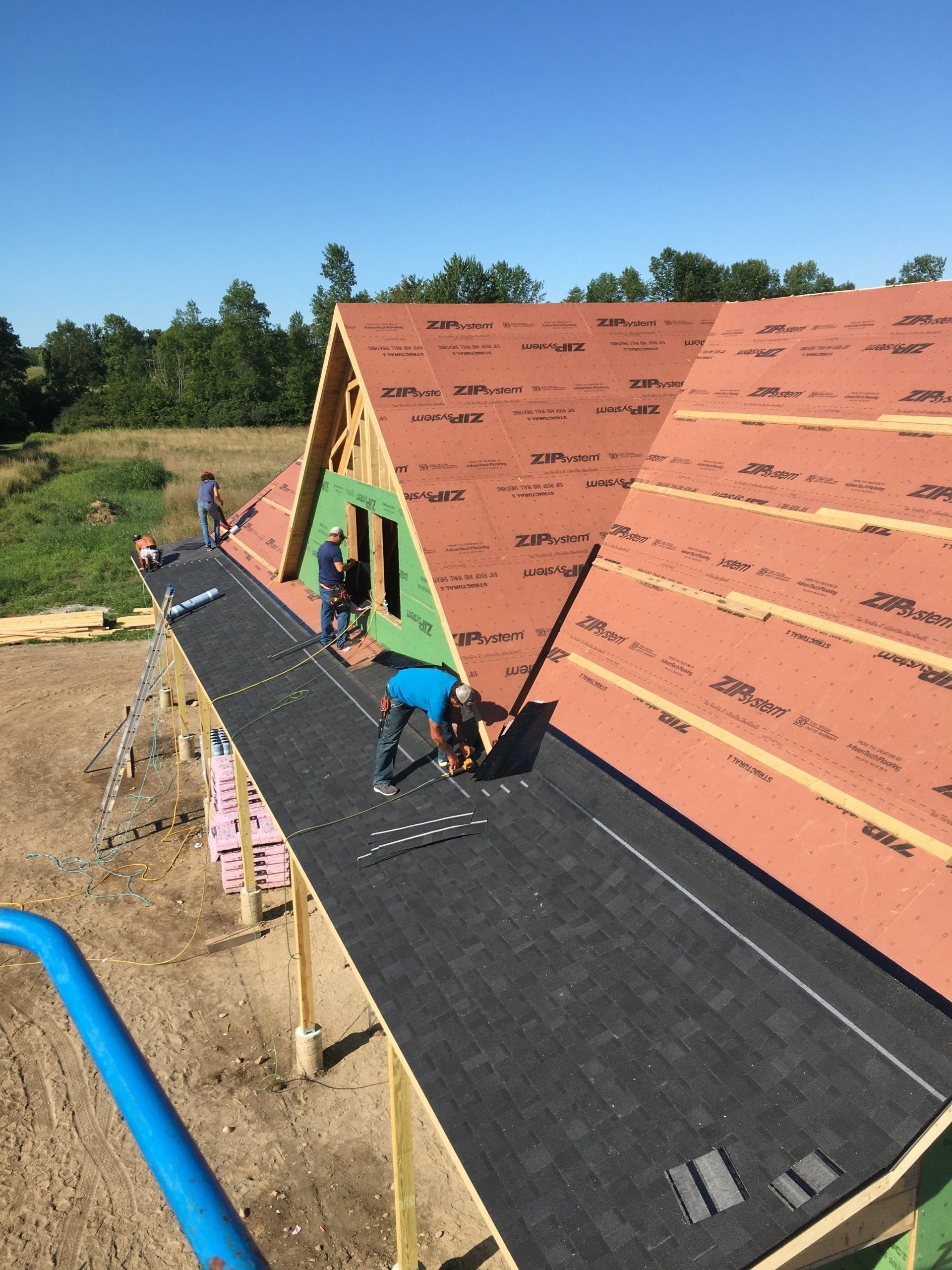 A man is working on the roof of a house under construction