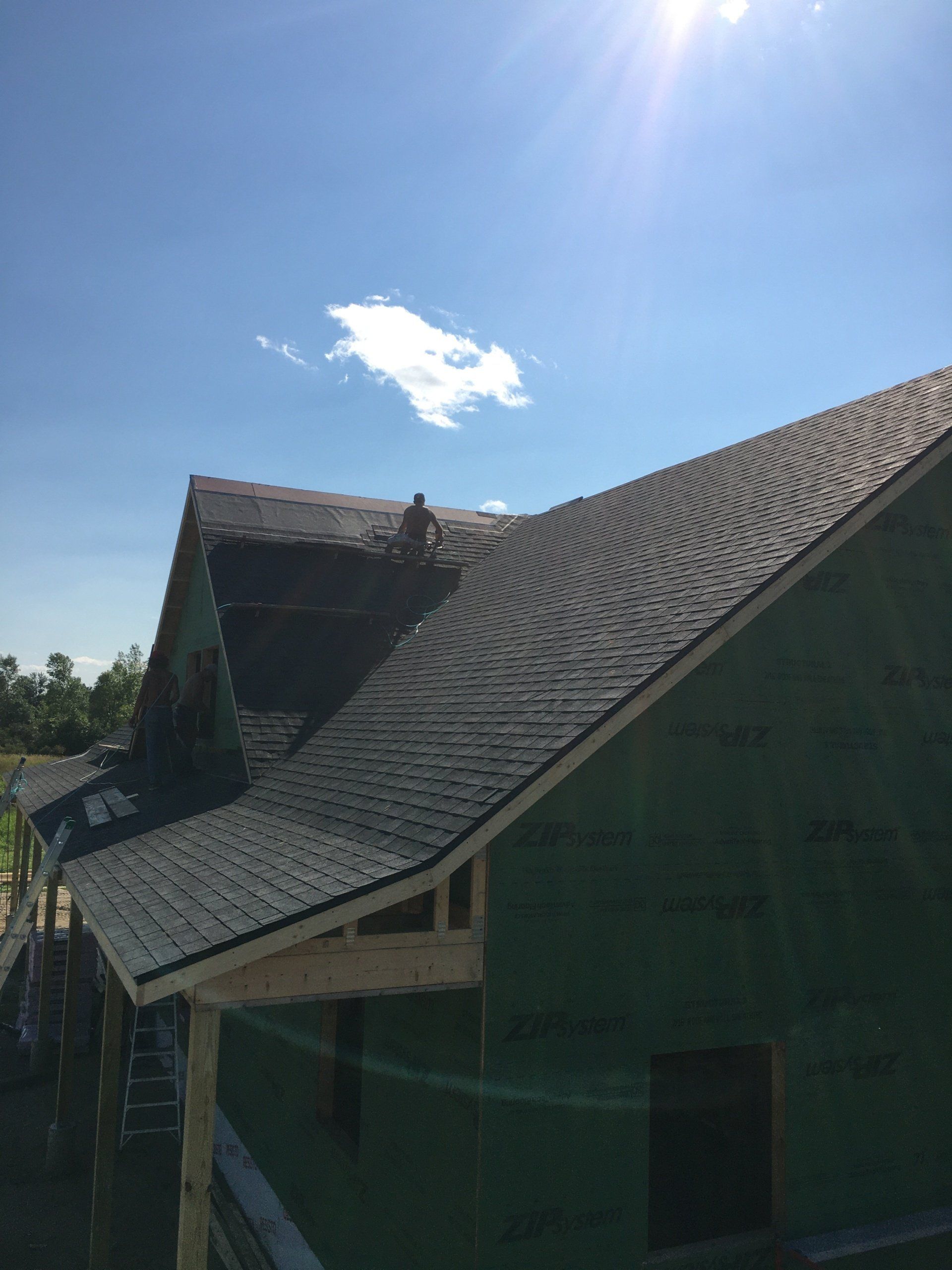 A man is working on the roof of a house under construction.