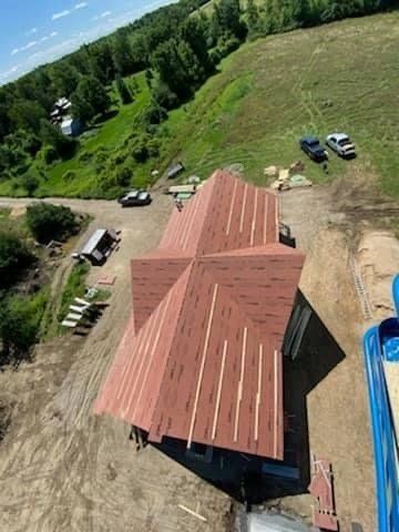 An aerial view of a house under construction with a red roof.