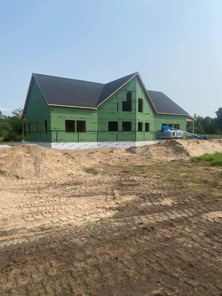 A house is being built in a dirt field.