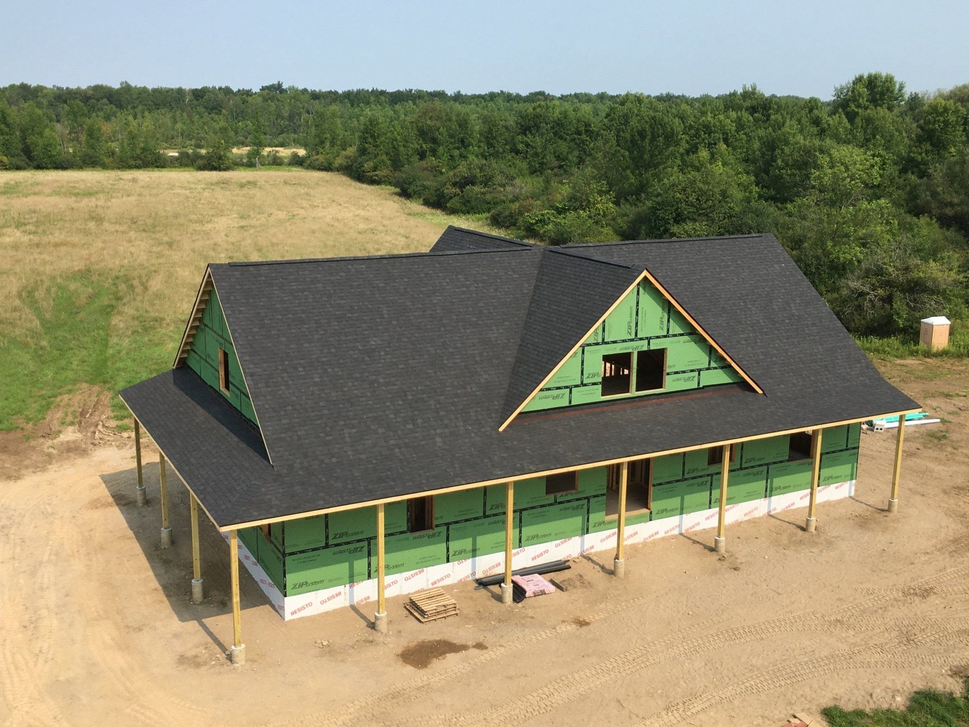 An aerial view of a house under construction in the middle of a field.