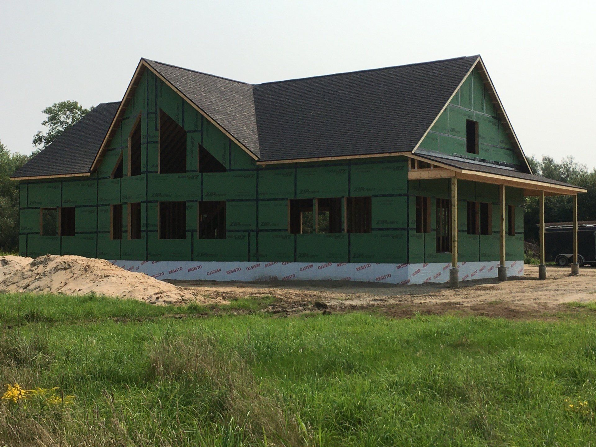 A house is being built in the middle of a grassy field.