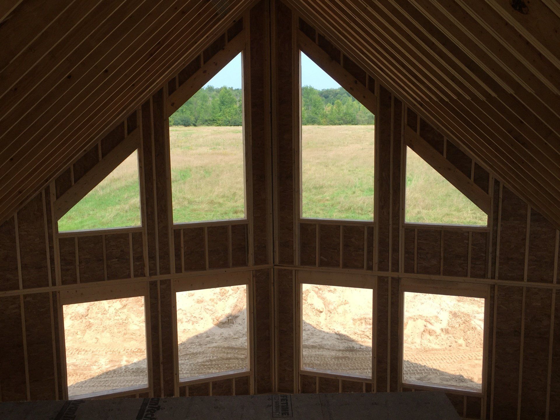 A house with a lot of windows and a field in the background