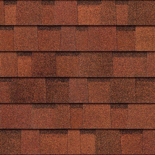A close up of a row of red shingles on a roof.