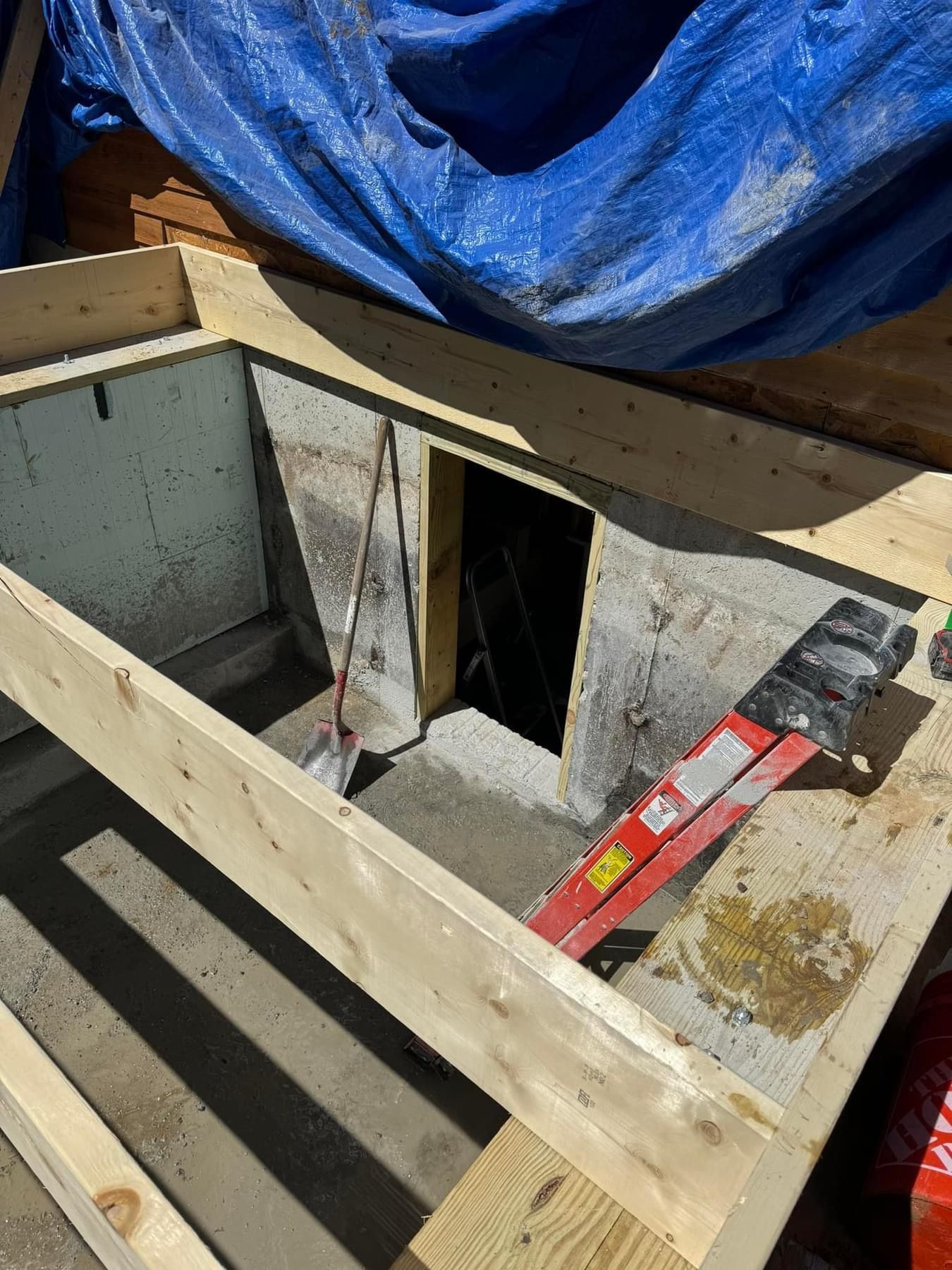 A wooden frame is being built around a hole in the ground.