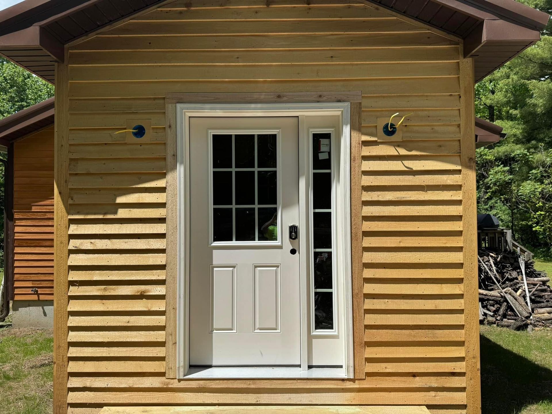 A small wooden house with a white door and window.