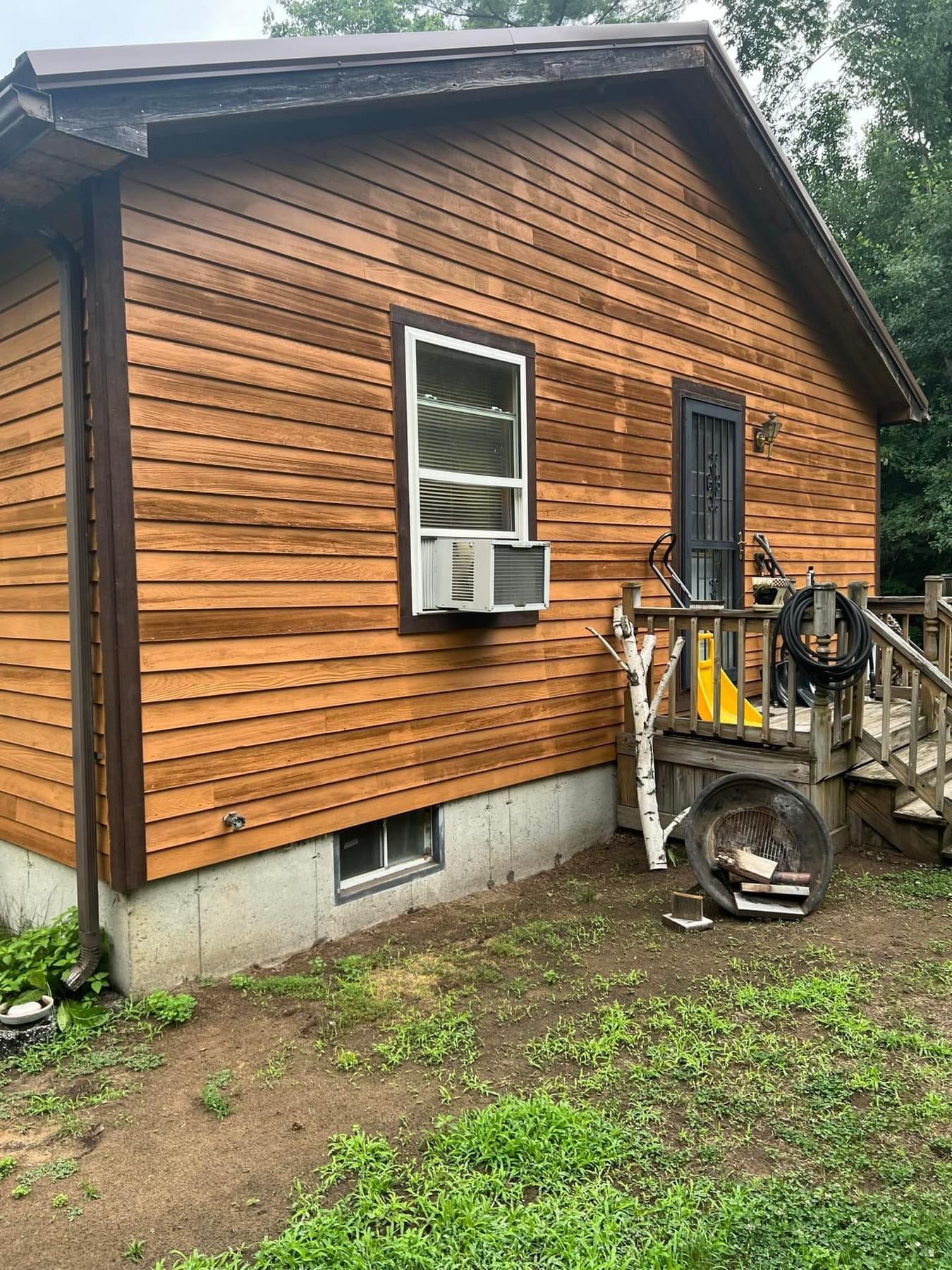A small house with a wooden siding and a window.