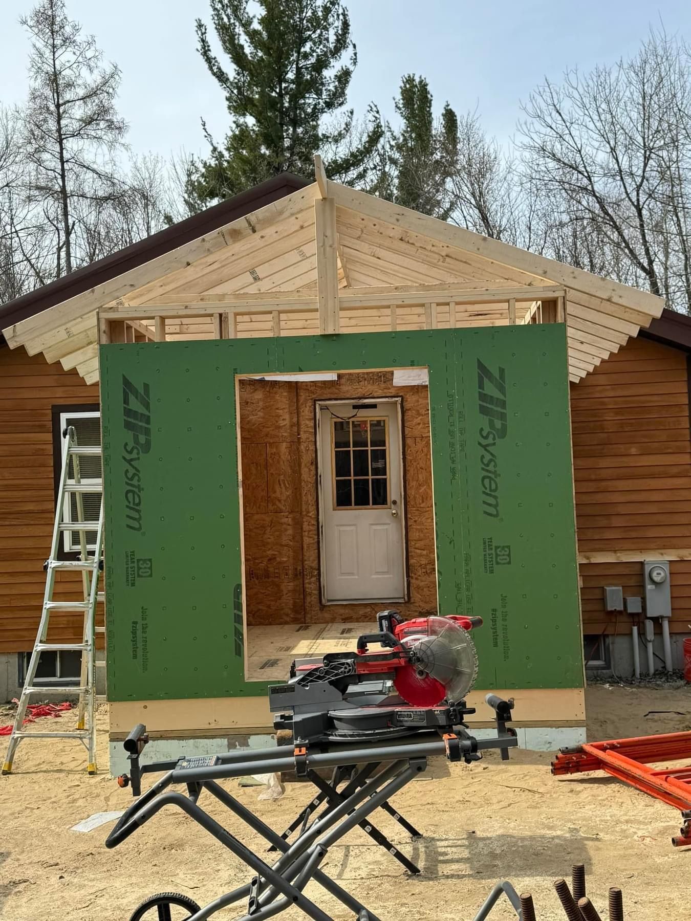 A house is being built with a circular saw in front of it.