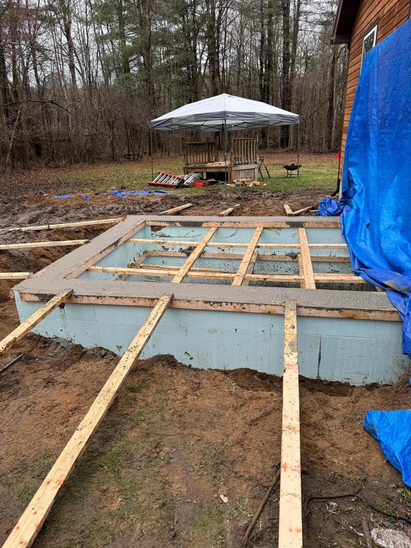 A wooden deck is being built in front of a house.
