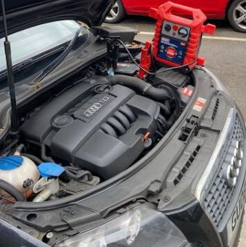 The engine of an audi is shown with the hood open