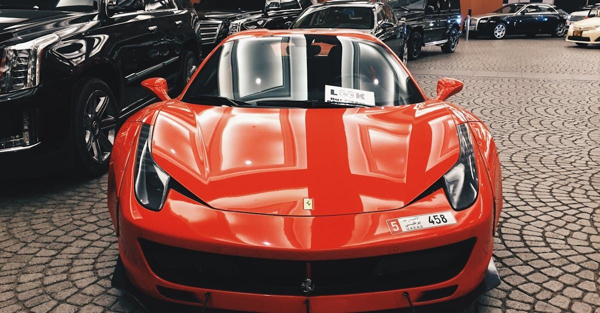 A red sports car is parked on a cobblestone street.