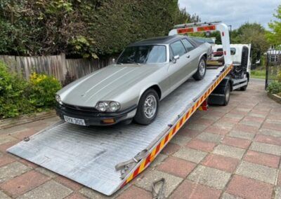 A car is being towed down a ramp by a tow truck.