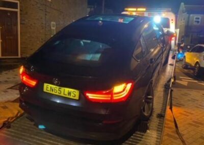 A black car with a license plate that says en65 lws