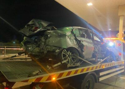 A wrecked car is sitting on top of a tow truck.