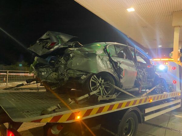 A wrecked car is sitting on top of a tow truck.