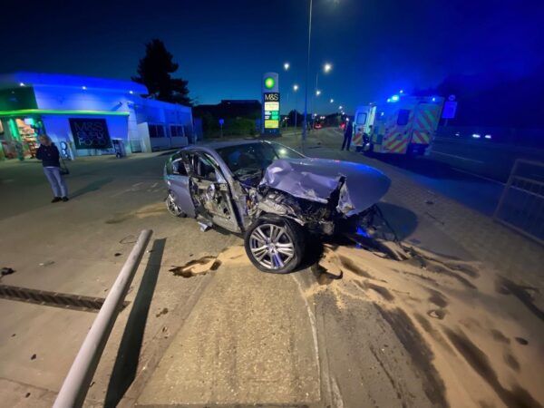 A car that has crashed into a pole on the side of the road