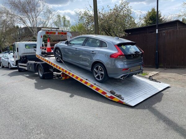 A car is being towed by a tow truck.