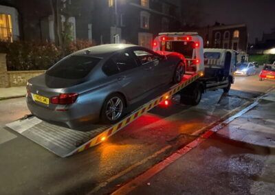A car is being towed by a tow truck on a ramp.