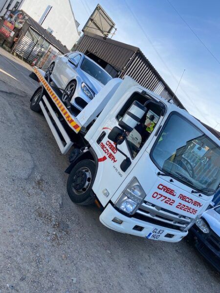 A tow truck with a car on the back of it