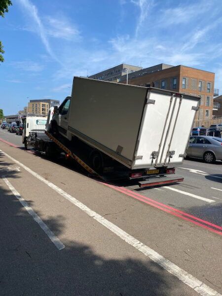 A white truck is sitting on the side of the road