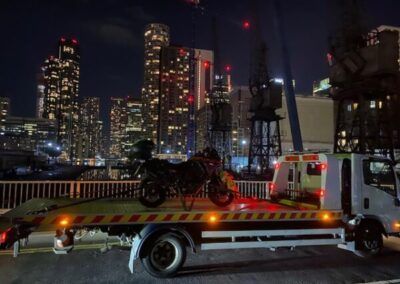 A motorcycle is sitting on the back of a tow truck.