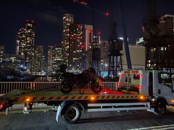 A motorcycle is sitting on top of a tow truck.