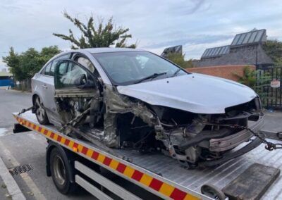 A wrecked car is sitting on top of a tow truck.