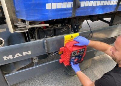 A man wearing blue gloves is working on a man truck.