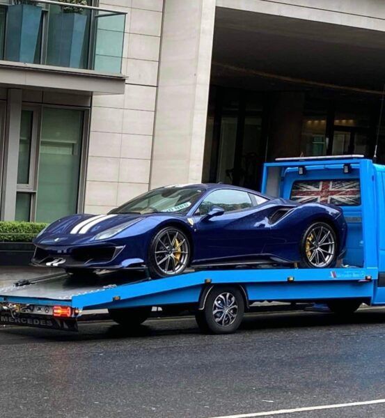 A blue car is sitting on top of a blue tow truck