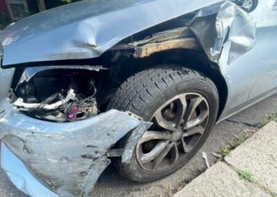 A damaged car is parked on the side of the road.
